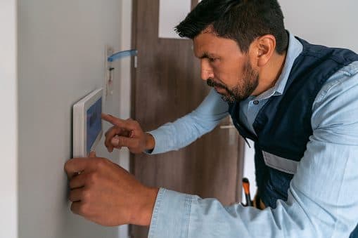 Technician programming a wall-mounted smart security keypad