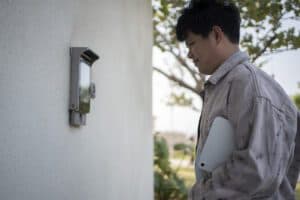 Man carrying tablet computer and passing building wall entry system controller