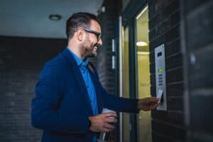 Business manager swiping a card at building intercom access system