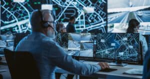 A team of security operators observing real-time system dashboards in a modern security center