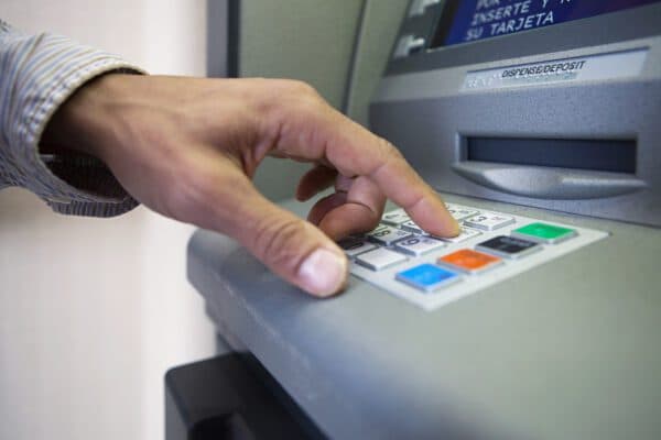 Customer entering PIN on ATM keypad