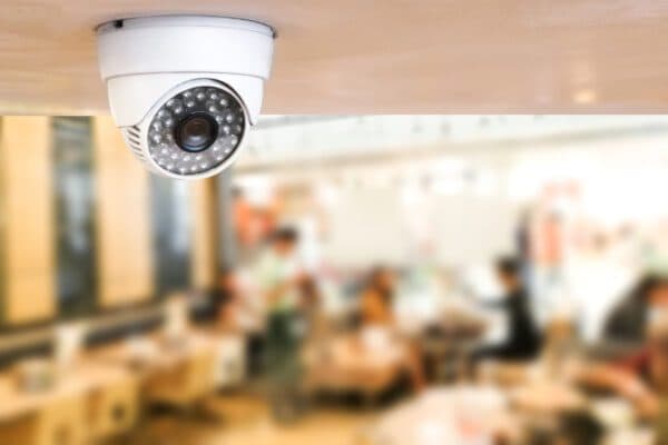White dome security camera mounted on a restaurant ceiling