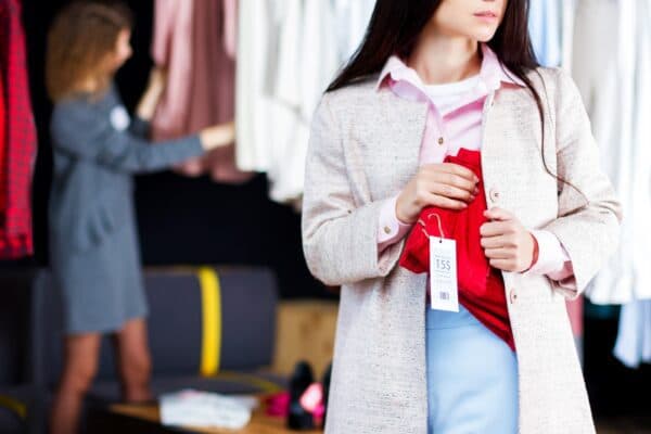 Store shopper concealing merchandise under coat to demonstrate retail shrinkage
