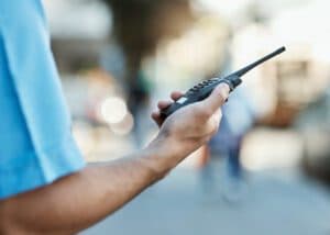 Close-up of a hand holding a walkie-talkie radio outdoors